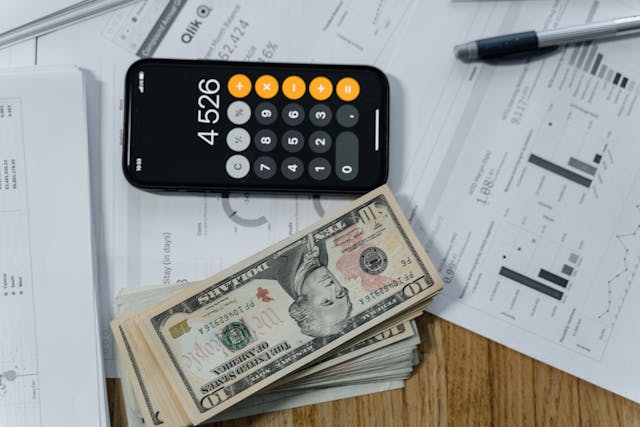 Cash and a Calculator on White Paper