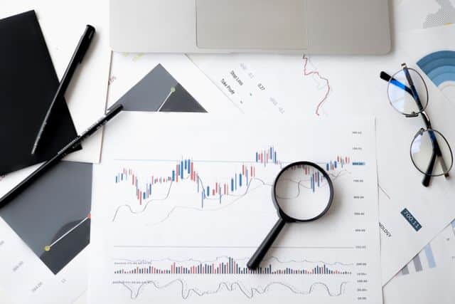 market analysis documents with magnifying glass